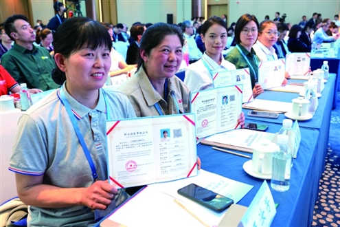 4月28日,长期照护师代表在活动中展示证书 新华社发